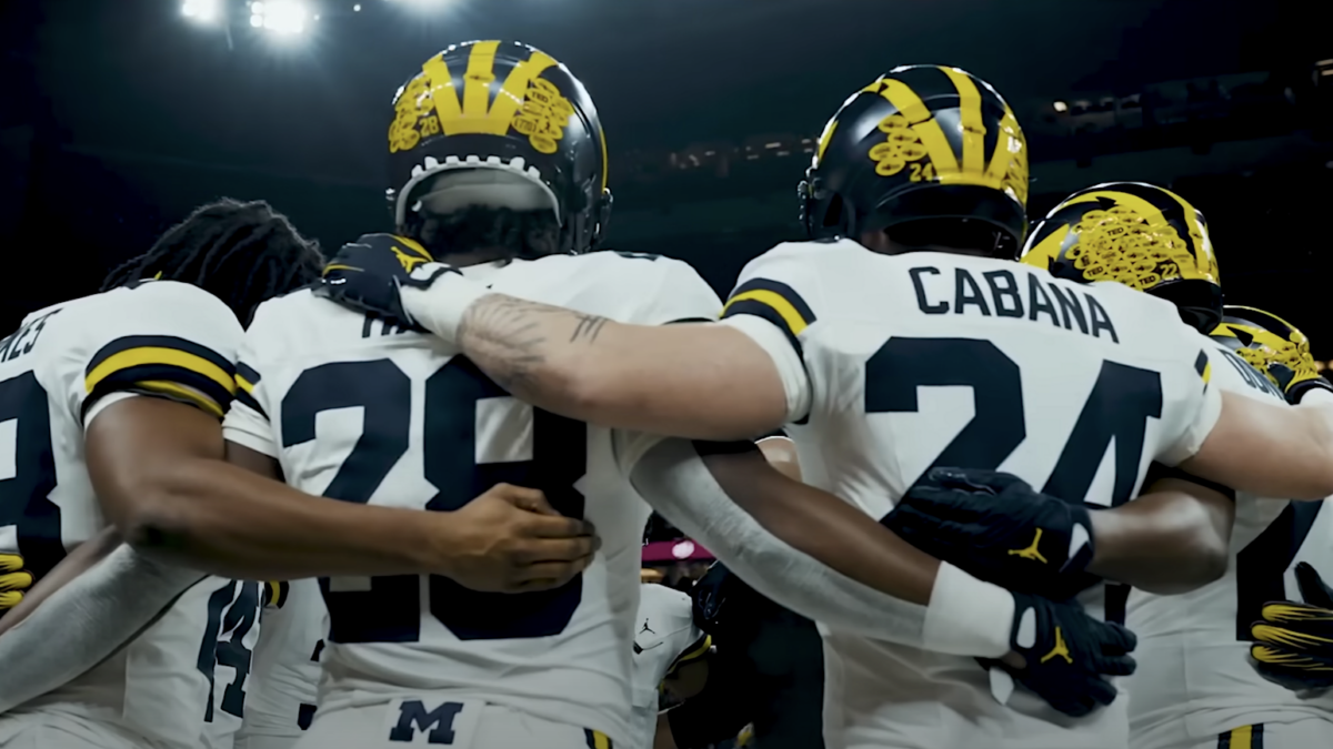 Michigan football players in a huddle